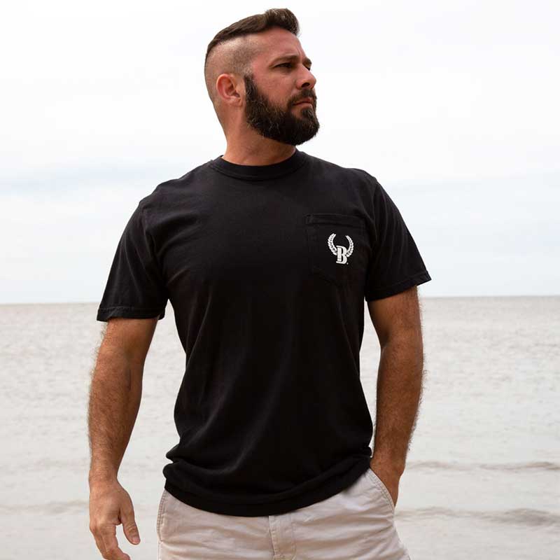 A man with a beard and mustache standing on the beach