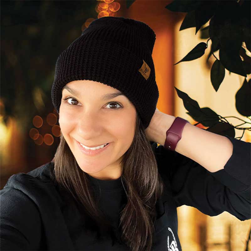 A woman wearing a black beanie and smiling.