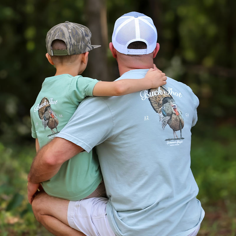Father-And-Son-tuckey-tom Father and son wearing matching Buck Shot Boss Tom t-shirts