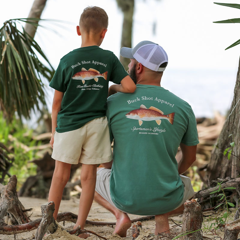 redfish-beach-back Father and son posing together wearing matching Buck Shot Redfish short sleeve t-shirts